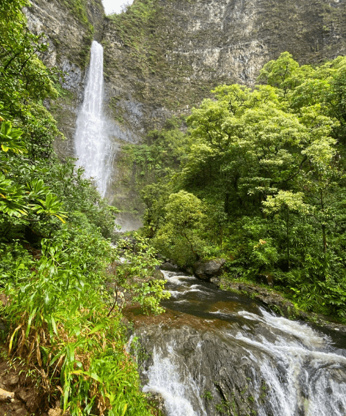 Hanakapai Falls in Kauai, Hawaii, a stunning 300-foot waterfall surrounded by lush tropical forests, viewed from the Kalalau Trail.
