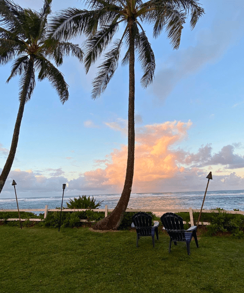 Sunset view at a beach bar in Hawaii with kawaii decor and tropical ambiance, highlighting the vibrant sky and ocean.