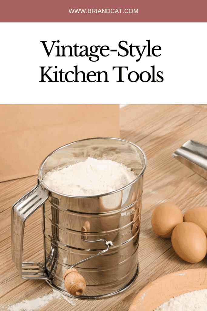 A vintage-style flour sifter sitting on a wooden countertop, with a few eggs nearby and flour scattered on the surface.