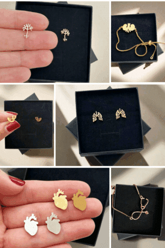 A collage of various pieces of anatomy-themed jewelry, including tree-shaped pins, heart-shaped pins, lungs earrings, and a stethoscope necklace, displayed in a black jewelry box.