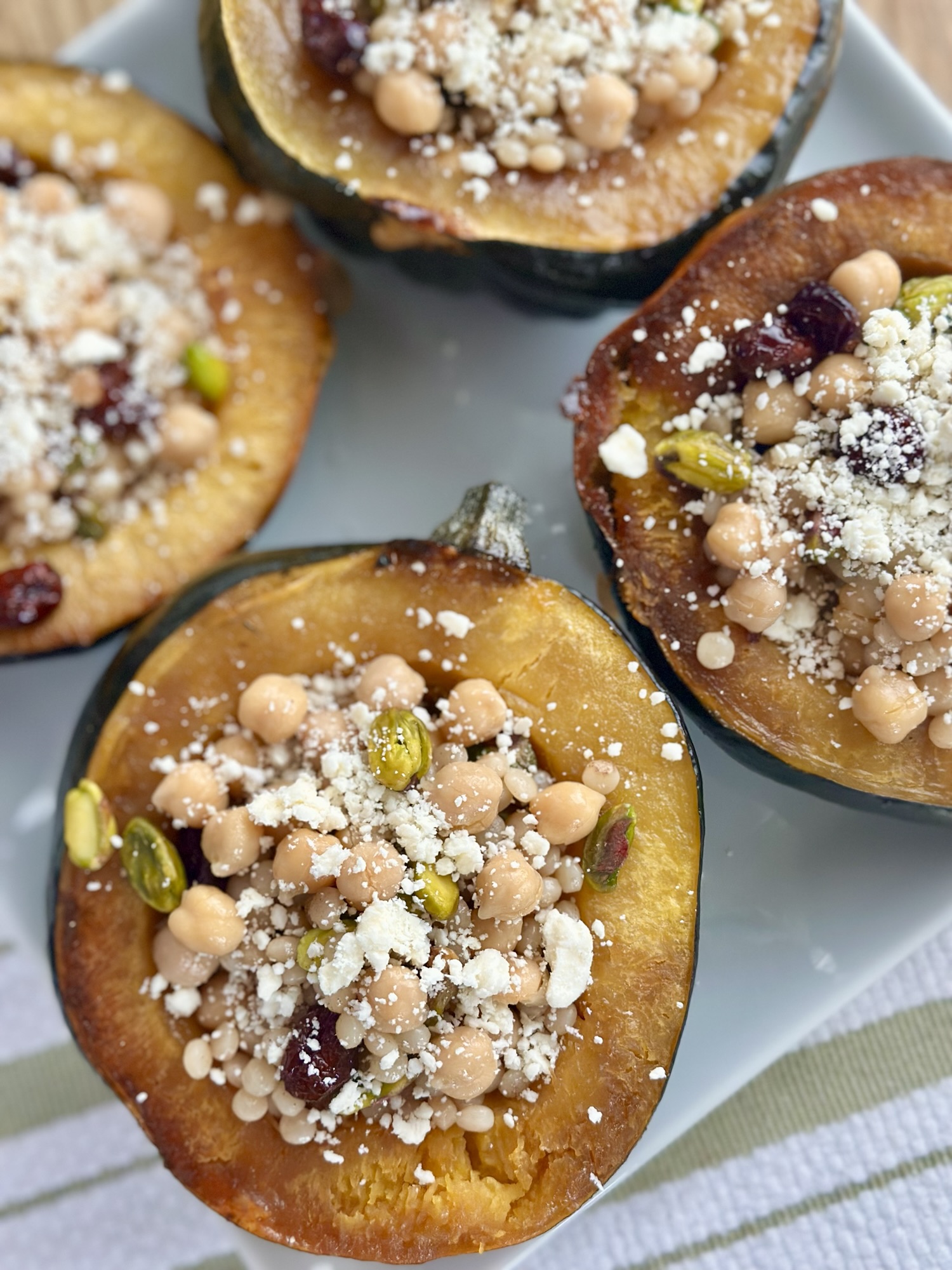 Stuffed Acorn Squash with Pumpkin Pie Spice Cous Cous, Pistachios, Cranberries & Feta