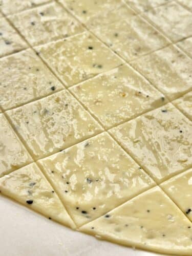 Close-up of rolled cracker dough, scored into squares, ready for baking.