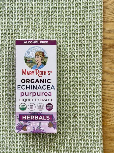 A box of MaryRuth's Organic Echinacea Purpurea Liquid Extract, placed on a textured green fabric surface.