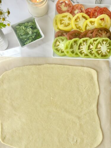 Puff pastry sheet rolled out on parchment paper to the size of a baking sheet