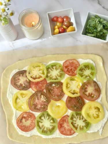 Sliced heirloom tomatoes layered over whipped feta on puff pastry
