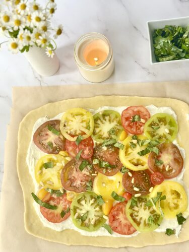 Heirloom tomato puff pastry tart topped with whipped feta, basil, and pine nuts