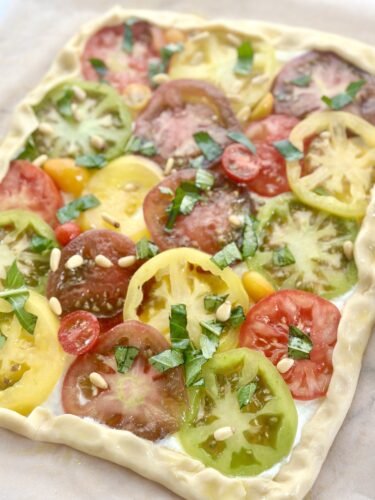 Sliced heirloom tomatoes layered over whipped feta on puff pastry
