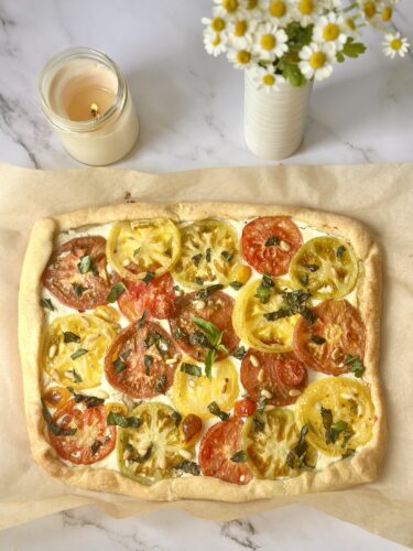 Golden flaky crust of a baked heirloom tomato tart with whipped feta