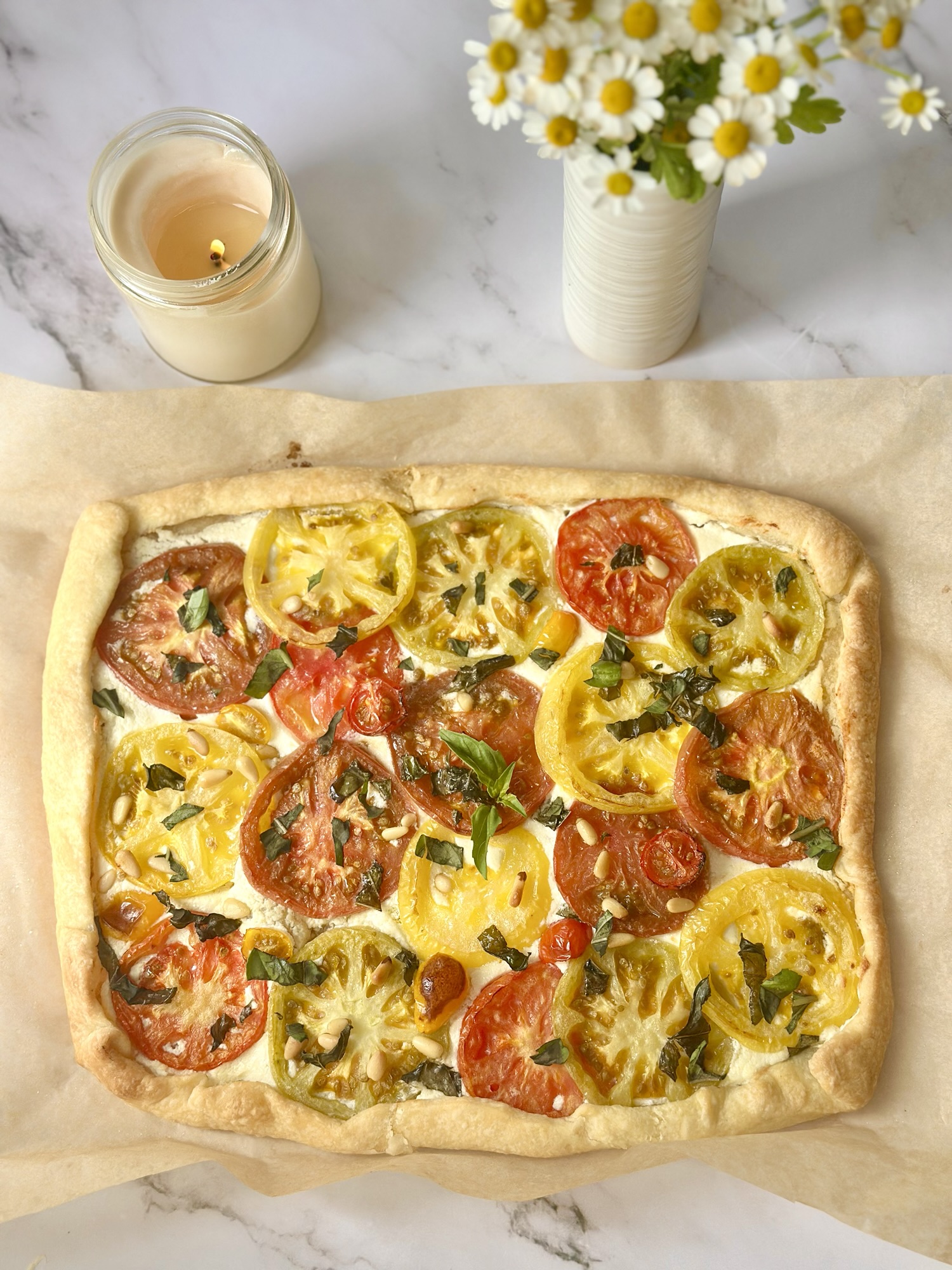 Golden flaky crust of a baked heirloom tomato tart with whipped feta