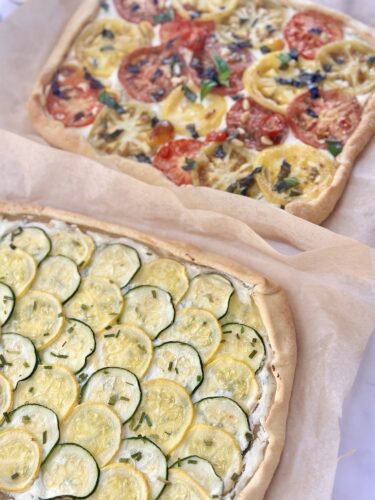 Whole heirloom tomato puff pastry tart on a baking sheet fresh from the oven